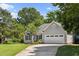 Beautiful one-story home with a manicured lawn, lush landscaping, and an attached two car garage at 6 Danesfield Ct, Durham, NC 27707