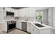 Well-lit kitchen boasts stainless steel appliances, white cabinetry, and quartz countertops at 6 Danesfield Ct, Durham, NC 27707