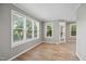 Sun-filled living room featuring multiple windows, beautiful hardwood floors, and seamless transitions to other living spaces at 6 Danesfield Ct, Durham, NC 27707
