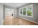 Sunlit living room with hardwood floors, large windows showcasing mature trees, creating a serene atmosphere at 6 Danesfield Ct, Durham, NC 27707