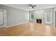 Bright living room featuring hardwood floors, a cozy fireplace, and large windows, offering a comfortable space to relax at 6 Danesfield Ct, Durham, NC 27707