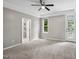 Spacious main bedroom with ensuite bathroom and exterior door with tray ceiling and ceiling fan at 6 Danesfield Ct, Durham, NC 27707