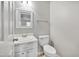Half-bathroom with a white vanity, brushed gold fixtures, and a mirror at 6927 Beaverwood Dr Dr, Raleigh, NC 27616