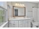 Bright bathroom featuring double sinks with white countertop, a window, and modern lighting at 6927 Beaverwood Dr Dr, Raleigh, NC 27616