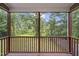 View from screened porch with wood railing overlooks lush green backyard at 6927 Beaverwood Dr Dr, Raleigh, NC 27616