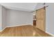 Bedroom with bathroom access, featuring hardwood floors and a sliding barn door at 700 Bishops Park Dr # 302, Raleigh, NC 27605