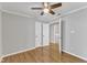Bedroom featuring hardwood floors, a ceiling fan, and access to laundry room at 700 Bishops Park Dr # 302, Raleigh, NC 27605