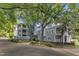 Attractive gray condos nestled among mature shade trees feature brick driveways and manicured landscaping at 700 Bishops Park Dr # 302, Raleigh, NC 27605