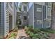 Gray condos with lush landscaping featuring a brick pathway entrance with the unit numbers on the building at 700 Bishops Park Dr # 302, Raleigh, NC 27605