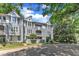 Charming gray condos boast balconies, brick walkways, and are surrounded by lush trees and blue skies at 700 Bishops Park Dr # 302, Raleigh, NC 27605
