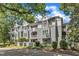 Beautiful condos with gray siding, bright white trim, patios, and balconies, surrounded by mature trees at 700 Bishops Park Dr # 302, Raleigh, NC 27605