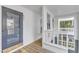Hallway and door to a unit with white walls and railings, and wood plank flooring at 700 Bishops Park Dr # 302, Raleigh, NC 27605
