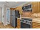 Bright kitchen view featuring stainless steel appliances, wood cabinets and exposed brick accents at 700 Bishops Park Dr # 302, Raleigh, NC 27605