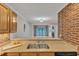 Bright open kitchen view to living room featuring granite countertops and exposed brickwork at 700 Bishops Park Dr # 302, Raleigh, NC 27605