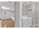 Laundry room featuring modern washer and dryer, wire shelving, and access to finished bonus room at 700 Bishops Park Dr # 302, Raleigh, NC 27605