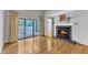 Spacious living room with hardwood floors, fireplace, sliding doors leading to a patio, and built-in shelving at 700 Bishops Park Dr # 302, Raleigh, NC 27605
