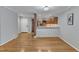 Open-concept living area showcases hardwood floors flowing into the adjacent kitchen with brick accents at 700 Bishops Park Dr # 302, Raleigh, NC 27605