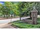 Inviting street corner with manicured lawn, mature trees, and clear signage at 700 Bishops Park Dr # 302, Raleigh, NC 27605