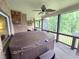 Relax in the screened porch with a spa tub, wood floors, a brick wall and an outdoor ceiling fan at 7483 Danford Rd, Burlington, NC 27215
