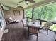 Enjoy outdoor living in this screened-in porch with ceiling fans, a table and comfortable seating at 7483 Danford Rd, Burlington, NC 27215