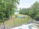 Spacious backyard with lake view, in-ground swimming pool, trampoline, and mature trees for privacy at 7483 Danford Rd, Burlington, NC 27215