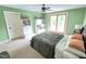 Green bedroom with a ceiling fan and patio door to the outside, along with built-in shelving at 7483 Danford Rd, Burlington, NC 27215