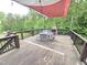 Backyard deck offering an outdoor dining area with metal seating, a wood fireplace, and wooded views at 7483 Danford Rd, Burlington, NC 27215