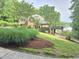 Beautiful landscaped property with a brick house featuring a deck and serene lake views at 7483 Danford Rd, Burlington, NC 27215