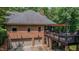 Brick house exterior with a deck, three-car garage and wooded surroundings at 7483 Danford Rd, Burlington, NC 27215