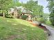Spacious brick home with lush landscaping, a lake view, and a large yard at 7483 Danford Rd, Burlington, NC 27215