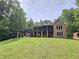 Expansive backyard featuring a large brick home with a screened porch, deck and lush lawn at 7483 Danford Rd, Burlington, NC 27215