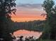 Picturesque sunset view over the lake, framed by lush green trees at 7483 Danford Rd, Burlington, NC 27215