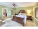 Spacious main bedroom with large bed, green walls, and bathroom ensuite access at 7483 Danford Rd, Burlington, NC 27215