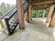 Spacious covered patio supported by brick columns and featuring a staircase to the backyard at 7483 Danford Rd, Burlington, NC 27215