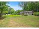 Large backyard with a garden, well-manicured lawn, and a wooden outbuilding at 8133 Holly Forest Rd, Wake Forest, NC 27587