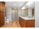 Spacious bathroom with wood cabinets, granite countertops, large mirror, and tiled glass shower at 8133 Holly Forest Rd, Wake Forest, NC 27587