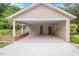Attached carport with two doors into the home, lights, and painted concrete at 8133 Holly Forest Rd, Wake Forest, NC 27587