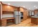 The kitchen features stainless steel appliances, wood cabinets, a built-in desk and wood flooring at 8133 Holly Forest Rd, Wake Forest, NC 27587