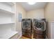 Laundry room with modern washer and dryer and white shelving at 8133 Holly Forest Rd, Wake Forest, NC 27587