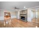Open floor plan with hardwood floors, a stone fireplace, and views into the kitchen and entry area at 8133 Holly Forest Rd, Wake Forest, NC 27587
