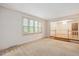 Bright living room with large windows and neutral carpeting at 8133 Holly Forest Rd, Wake Forest, NC 27587