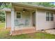 Covered porch with two green chairs, small table, and ceiling fan at 8133 Holly Forest Rd, Wake Forest, NC 27587