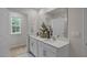 Well-lit bathroom featuring a double vanity, white cabinets, and a large mirror, creating a bright and airy space at 818 Comice Pear Way, Willow Springs, NC 27592