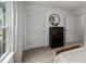 Bedroom with a decorative mirror, storage cabinet, and natural light from the window at 818 Comice Pear Way, Willow Springs, NC 27592