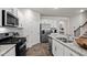 Bright kitchen with granite countertops, stainless steel appliances and a view of the stairway at 818 Comice Pear Way, Willow Springs, NC 27592