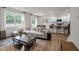 Bright, open-concept living room with a large sectional sofa and kitchen featuring a breakfast bar and modern appliances at 818 Comice Pear Way, Willow Springs, NC 27592