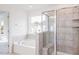 Well-lit bathroom features a soaking tub, glass-enclosed shower, and tiled surround at 925 Kinglet House Rd, Knightdale, NC 27545