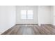 A clean, empty room featuring beautiful wood floors, a large window, and neutral walls at 925 Kinglet House Rd, Knightdale, NC 27545
