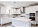 Bright kitchen featuring white cabinets, stainless appliances, an island, and modern pendant lights at 925 Kinglet House Rd, Knightdale, NC 27545