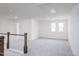Bright loft with new carpeting and view of staircase with wood and white railing at 925 Kinglet House Rd, Knightdale, NC 27545
